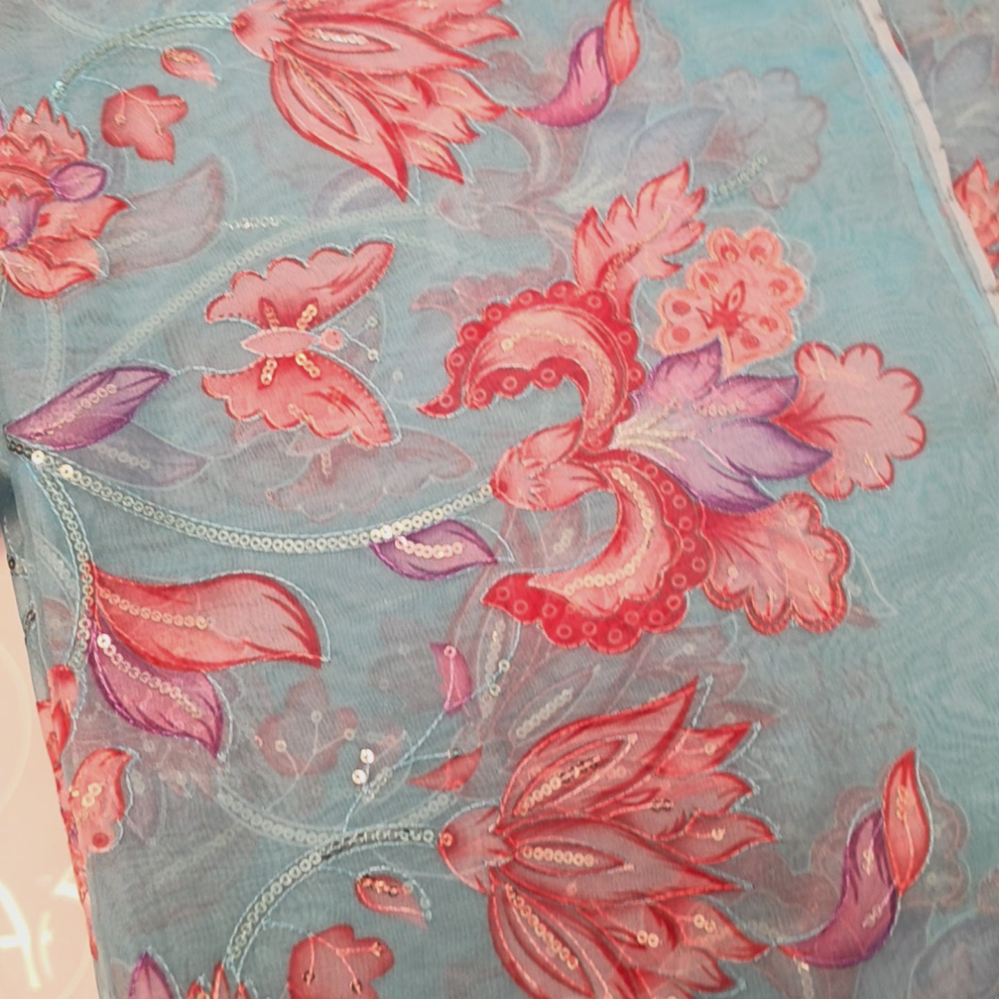 Skyblue Organza Saree with floral sequins all over paired with bright orange blouse