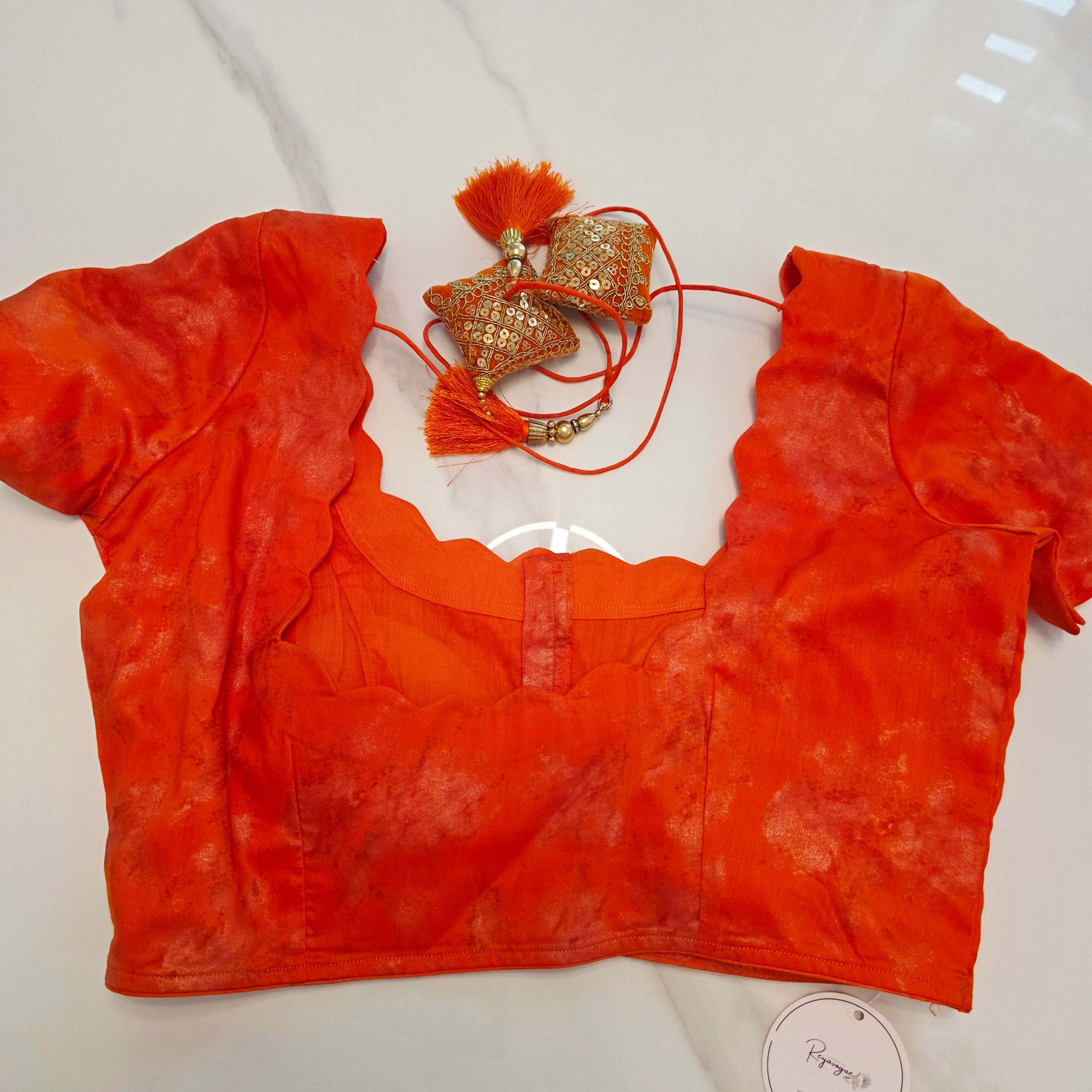 Himmelblaue Organza-Sari mit Blumenpailletten und leuchtend oranger Bluse