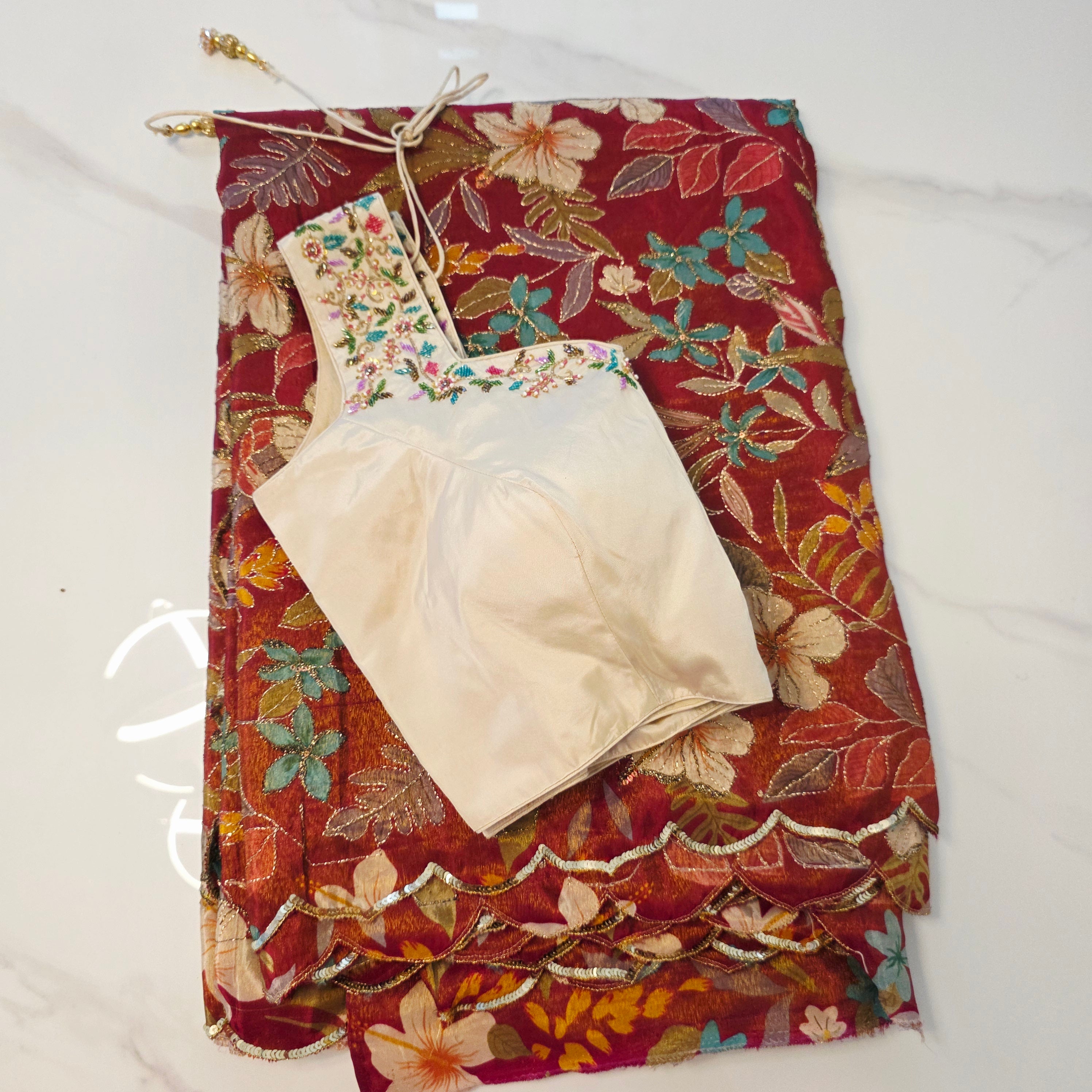 Maroon Tissue Saree with allover floral sequins paired with designer blouse