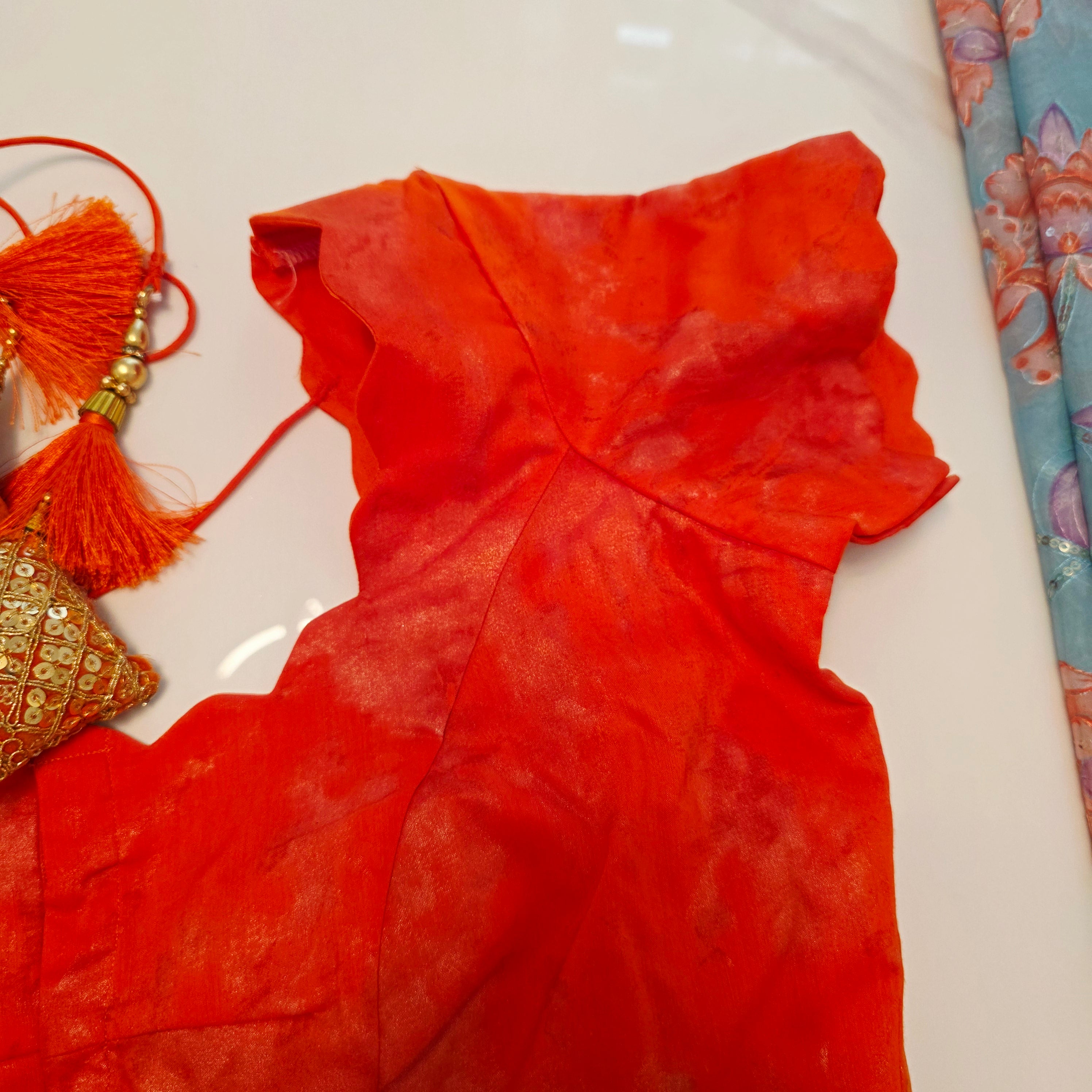 Himmelblaue Organza-Sari mit Blumenpailletten und leuchtend oranger Bluse