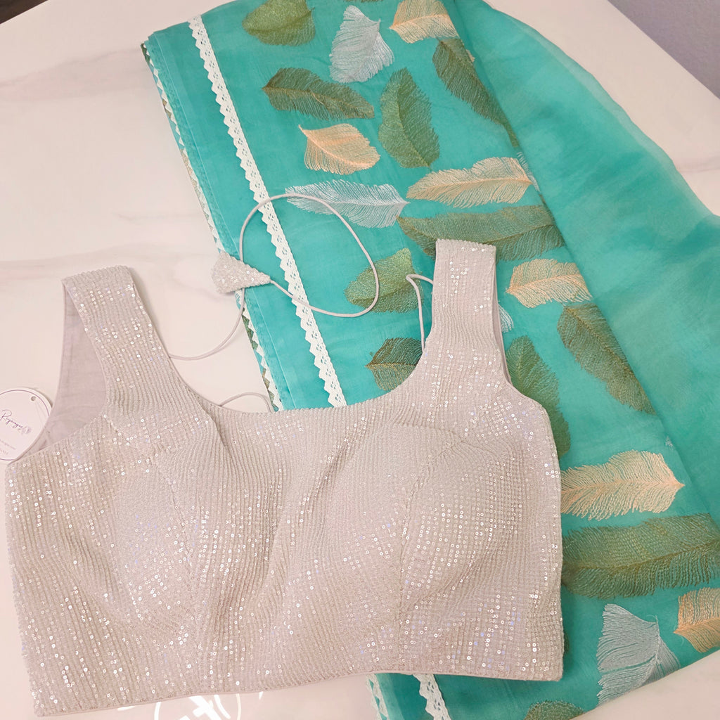 Petrolblaues Sari aus weicher Organza mit vollflächiger Blätterstickerei. Kombiniert mit einer weichen Paillettenbluse.
