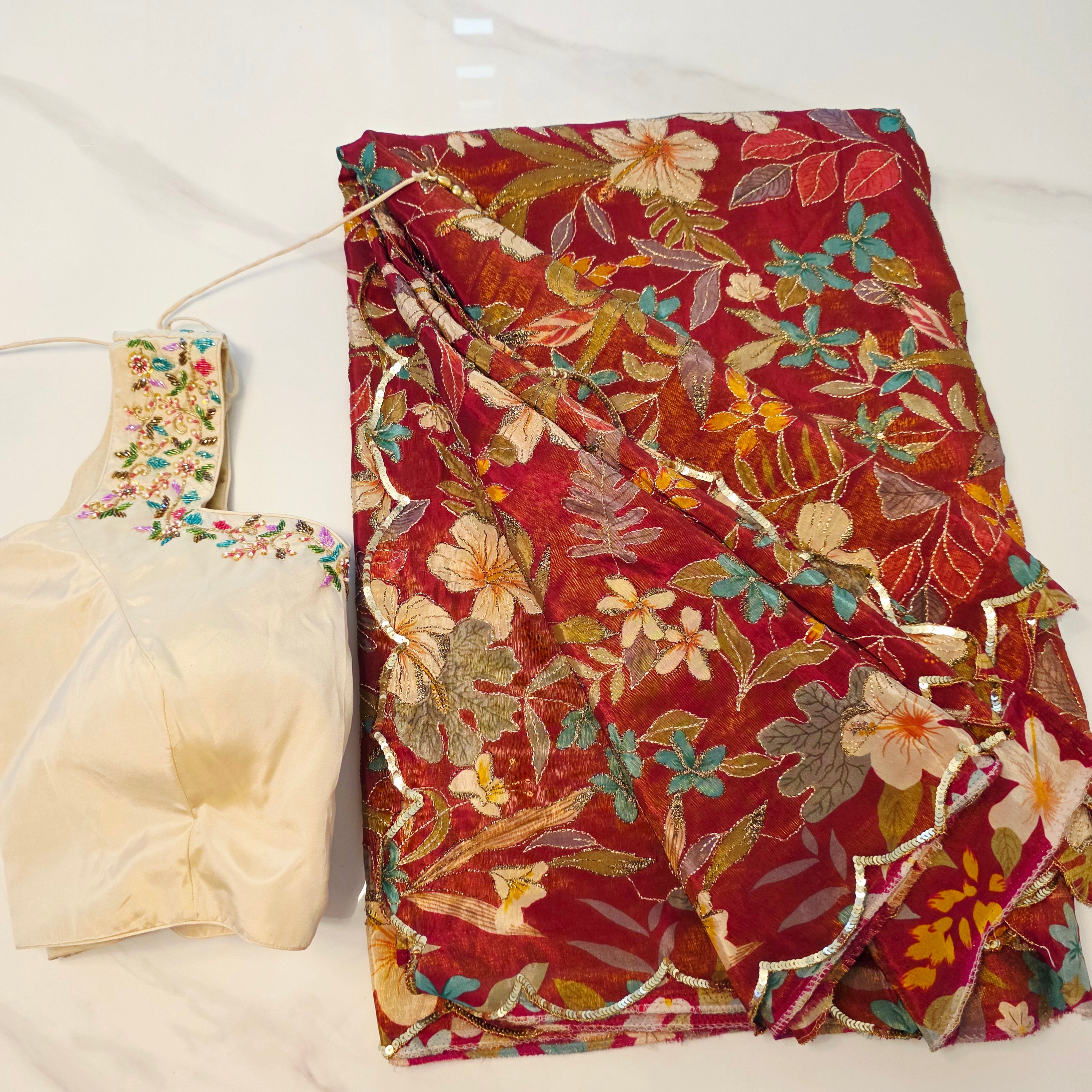 Maroon Tissue Saree with allover floral sequins paired with designer blouse