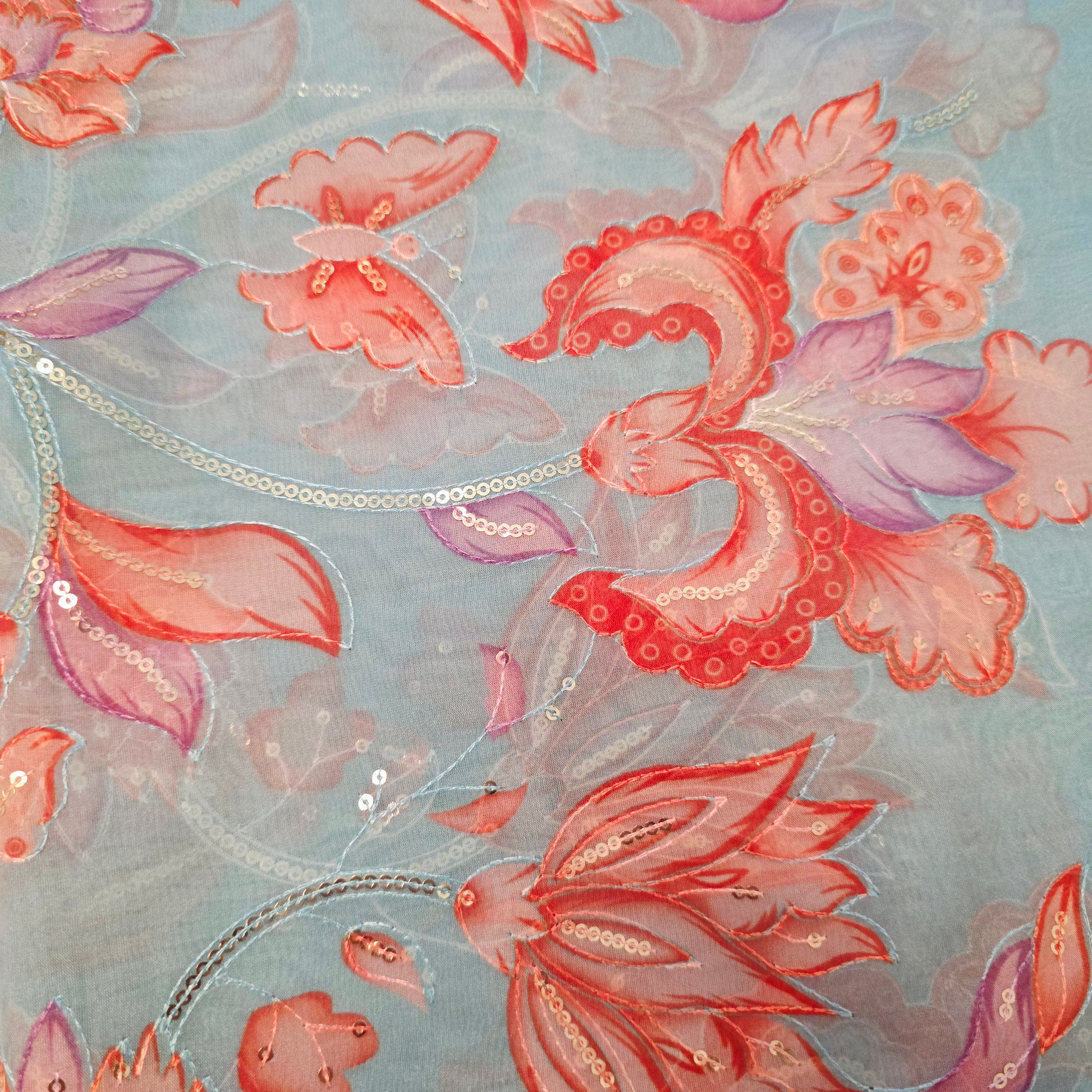 Himmelblaue Organza-Sari mit Blumenpailletten und leuchtend oranger Bluse